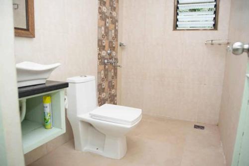 a bathroom with a white toilet and a shower at Casa Flore- 1bhk studio apt in Bardez