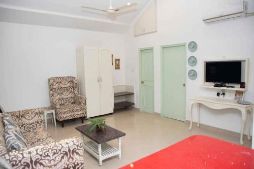 a living room with a couch and a tv at Casa Flore- 1bhk studio apt in Bardez