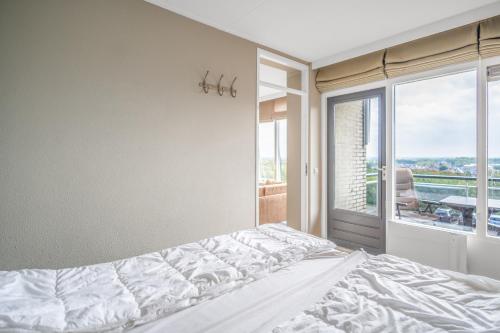 a bedroom with a bed and a large window at Appartementencomplex Juliana 178 in De Koog