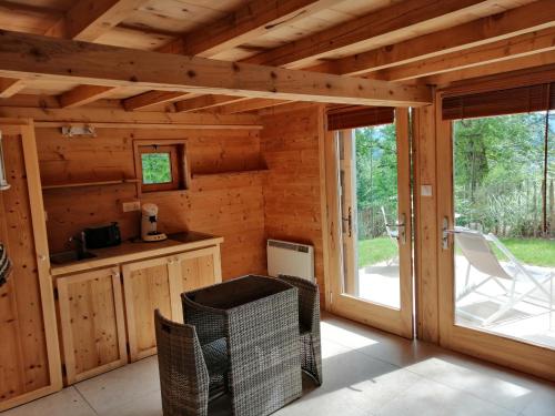 Ce chalet en rondins comprend une cuisine et une porte coulissante en verre. dans l'établissement Cabanon, à Sapois