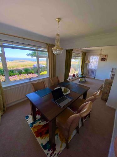 a dining room with a table with a laptop on it at 2 Bed Retreat with amazing see view in Brighton & Hove