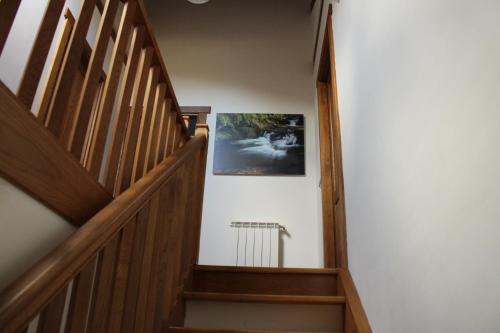 a hallway with wooden stairs and a picture on the wall at Apartamentos Irati in Espinal-Auzperri