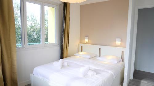 - 2 lits blancs dans une chambre avec fenêtre dans l'établissement Proche Croisette, Appartement 2 Chambres by Palmazur Vacances, à Cannes