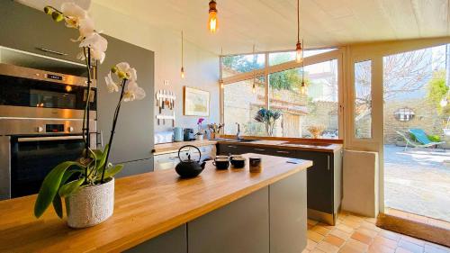 - une cuisine avec un comptoir orné d'un vase de fleurs dans l'établissement Maison de village familiale avec sa cour lumineuse, à La Couarde-sur-Mer