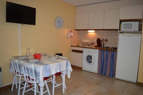 une cuisine avec une table avec des chaises et un micro-ondes dans l'établissement Appart Studio cabine 4 couchages BANYULS SUR MER BN010-001, à Banyuls-sur-Mer