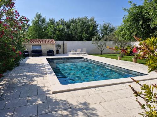 une piscine dans une cour avec un patio dans l'établissement Le refuge, à Bédarrides