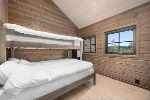 a bedroom with two bunk beds and a window at Gandalv Hytte - 8p - With Sauna & Hot Tub in Vradal
