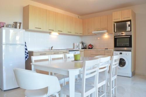 - une cuisine avec une table blanche et des appareils électroménagers blancs dans l'établissement Appart 3 pièces 4 couchages BANYULS SUR MER BN150-B11, à Banyuls-sur-Mer