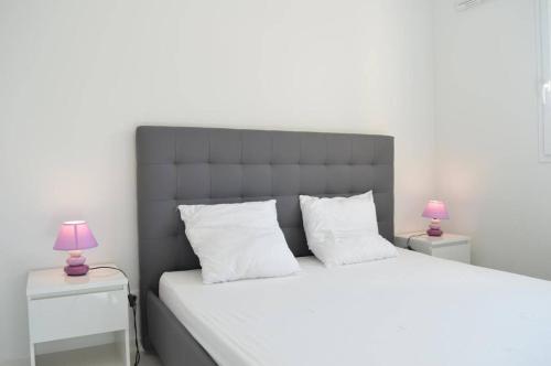 une chambre avec un grand lit blanc avec deux lampes dans l'établissement Appart 3 pièces 4 couchages BANYULS SUR MER BN150-B11, à Banyuls-sur-Mer