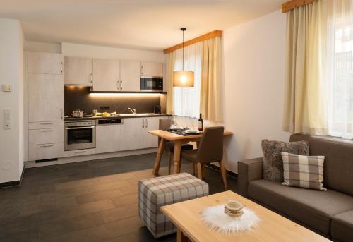 a living room with a couch and a table at AlpinLodges Kühtai in Kühtai
