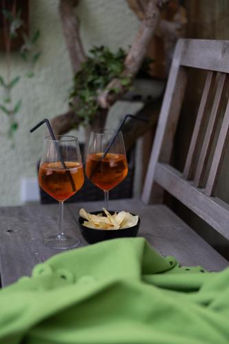 two wine glasses sitting on top of a wooden table at Zum Lindenwirt - Al Tiglio in Naz-Sciaves