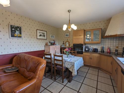 une cuisine avec une table, des chaises et un canapé dans l'établissement Charmante fermette avec jardin clos près du lac d'Eguzon - FR-1-591-623, à Gournay