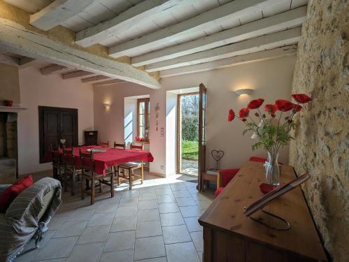 - un salon avec une table et des roses rouges dans l'établissement Charmante maison au cœur du Berry avec jardin et parking, proche Parc de la Brenne - FR-1-591-653, à Maillet