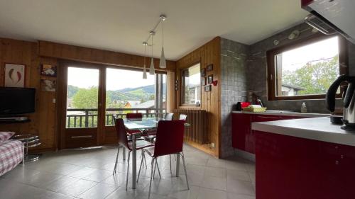 Il comprend une cuisine avec une table et des chaises. dans l'établissement Flocon U Bon Slo Megeve 2, à Megève