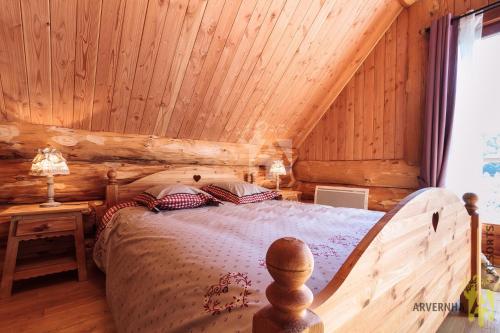a bedroom with a bed in a log cabin at Chalet de Fougerousse in Chambon-sur-Lac
