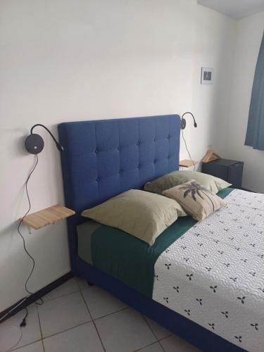 a bed with a blue headboard in a bedroom at Sweet room city center in Papeete