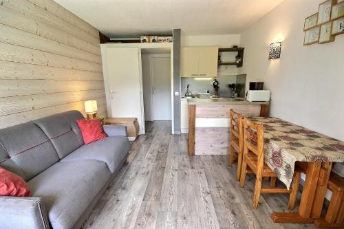 a living room with a couch and a table and a kitchen at SOLARET 001 - Studio cabine, 4pers - Centre Bourg Saint Maurice in Bourg-Saint-Maurice