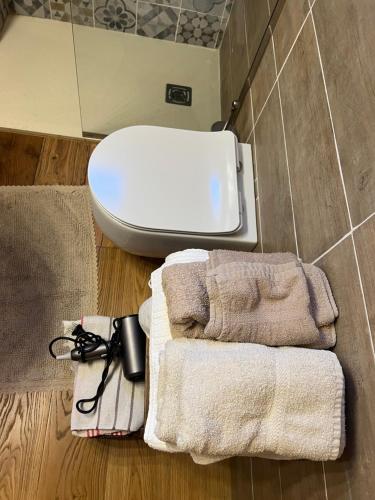 a bathroom with a toilet and towels on the floor at CASA ENRICA in Adelfia