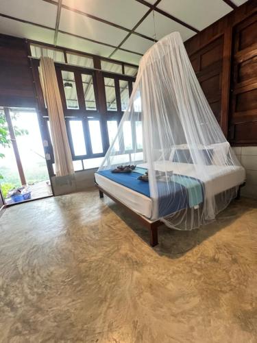 un dormitorio con una cama con mosquitera en Tiger homestay 2 Phayam, en Ko Phayam