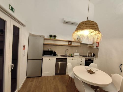 a small kitchen with a white table and a table and chairs at Monte de São Francisco Country House in Vale de Maceira