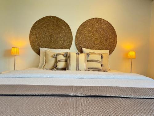 a bedroom with a bed with two large baskets at Monte de São Francisco Country House in Vale de Maceira