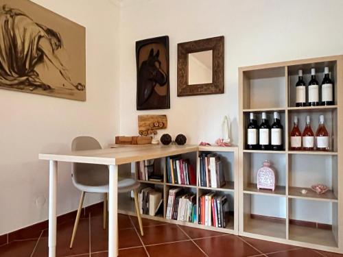 a table and a book shelf with wine bottles at Monte de São Francisco Country House in Vale de Maceira