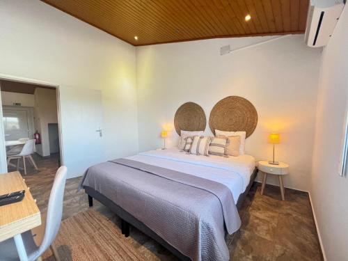 a bedroom with a large bed and a table at Monte de São Francisco Country House in Vale de Maceira