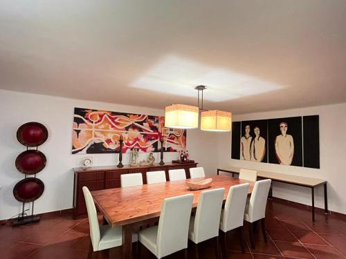 a dining room with a wooden table and white chairs at Monte de São Francisco Country House in Vale de Maceira