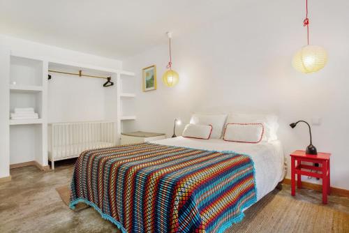 una camera da letto con un letto con una coperta colorata sopra di Calheta Beach House T1 a Calheta