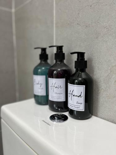 three bottles of moisturizers sitting on top of a counter at Industrial Luxe Concrete Bliss, near Sunway Pyramid,Subang Jaya in Subang Jaya