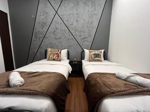 two beds sitting next to each other in a room at Industrial Luxe Concrete Bliss, near Sunway Pyramid,Subang Jaya in Subang Jaya