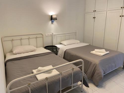 zwei Betten in einem Krankenhauszimmer mit Handtüchern darauf in der Unterkunft Angel's Apartment Volos in Volos