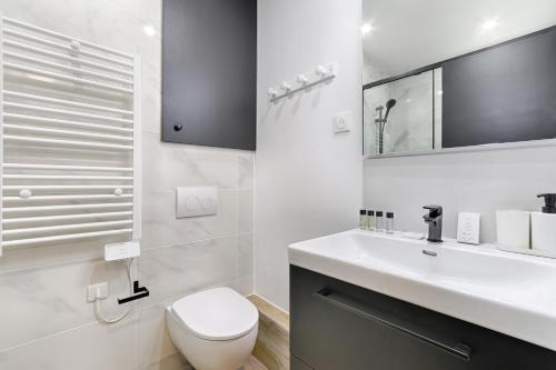 une salle de bain blanche avec des toilettes et un lavabo dans l'établissement Sentier Historical Center V Saint-Denis Greneta, à Paris