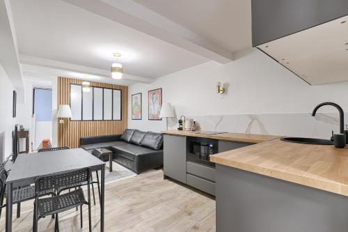 une cuisine et un salon avec un canapé et une table dans l'établissement Sentier Historical Center V Saint-Denis Greneta, à Paris