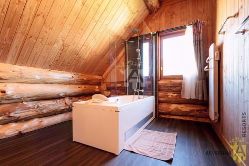 a bathroom with a tub and a sink in a room at Chalet de Fougerousse in Chambon-sur-Lac