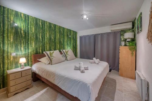 une chambre avec un grand lit avec un mur végétal dans l'établissement Évasion Thailandaise - Feng Shui - Parking, à Saint-Égrève