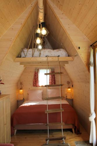 une chambre dans une cabane en rondins avec un lit dans l'établissement Chalet Miro, à Saint-Germain-dʼAunay