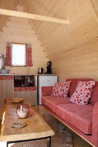 un salon avec un canapé rouge et une table dans l'établissement Chalet Miro, à Saint-Germain-dʼAunay