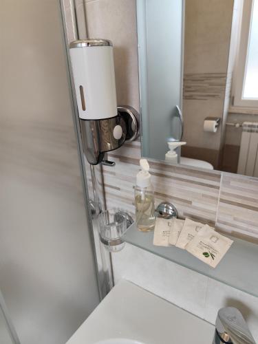 a bathroom with a sink and a mirror and a toilet at Belvedere Rooms Guest House in Rome