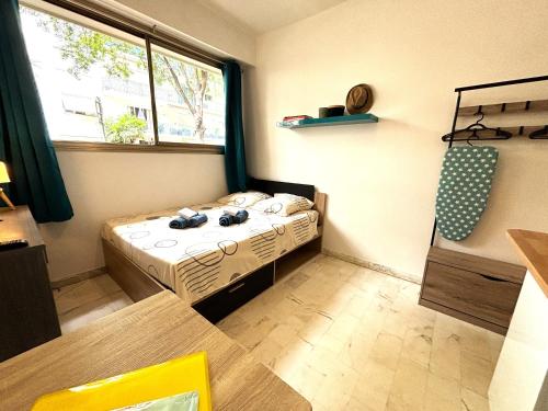 une petite pièce avec un lit et une fenêtre dans l'établissement Cannes center wifi AC 100 m from Croisette behind Martinez hotel, à Cannes