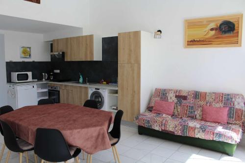 un salon avec une table et un canapé dans l'établissement PN000-053 Maison 6 couchages - PORT LA NOUVELLE, à Port-la-Nouvelle