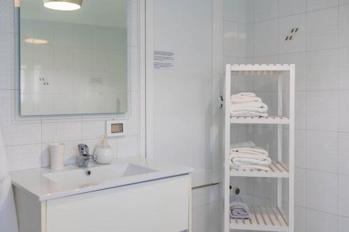 a bathroom with a sink and a shelf with towels at Antiche Mura Apartments"Cielo di Puglia" -2 matrimoniali, cucina e terrazzo in Turi