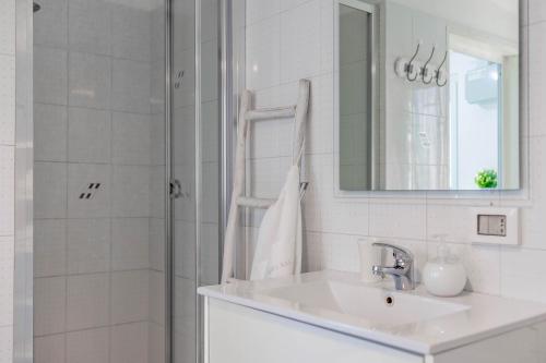 a bathroom with a sink and a shower with a mirror at Antiche Mura Apartments"Cielo di Puglia" -2 matrimoniali, cucina e terrazzo in Turi