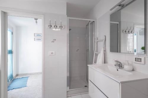 a white bathroom with a sink and a shower at Antiche Mura Apartments"Cielo di Puglia" -2 matrimoniali, cucina e terrazzo in Turi