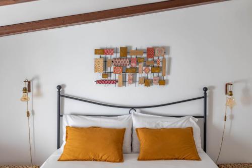 a bedroom with a bed with two orange pillows at Antiche Mura Apartments"Cielo di Puglia" -2 matrimoniali, cucina e terrazzo in Turi