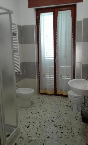 a bathroom with two toilets and a sink and a tub at B&B River in Ascoli Piceno