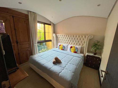 a bedroom with a bed with a teddy bear on it at Venetian Signature Pattaya by รมิตา in Jomtien Beach