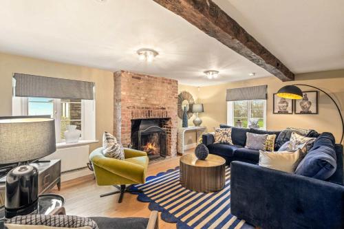 a living room with a blue couch and a fireplace at Great Easton Lodge in Great Easton