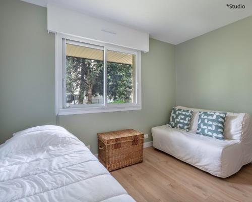 une chambre avec un lit, un canapé et une fenêtre dans l'établissement À 220m de la plage, appart avec terrasse pour 3, à La Baule