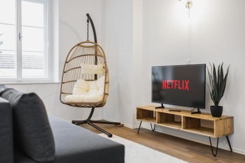 a living room with a tv and a chair at Design-Apartments in der Braunauer Altstadt in Braunau am Inn